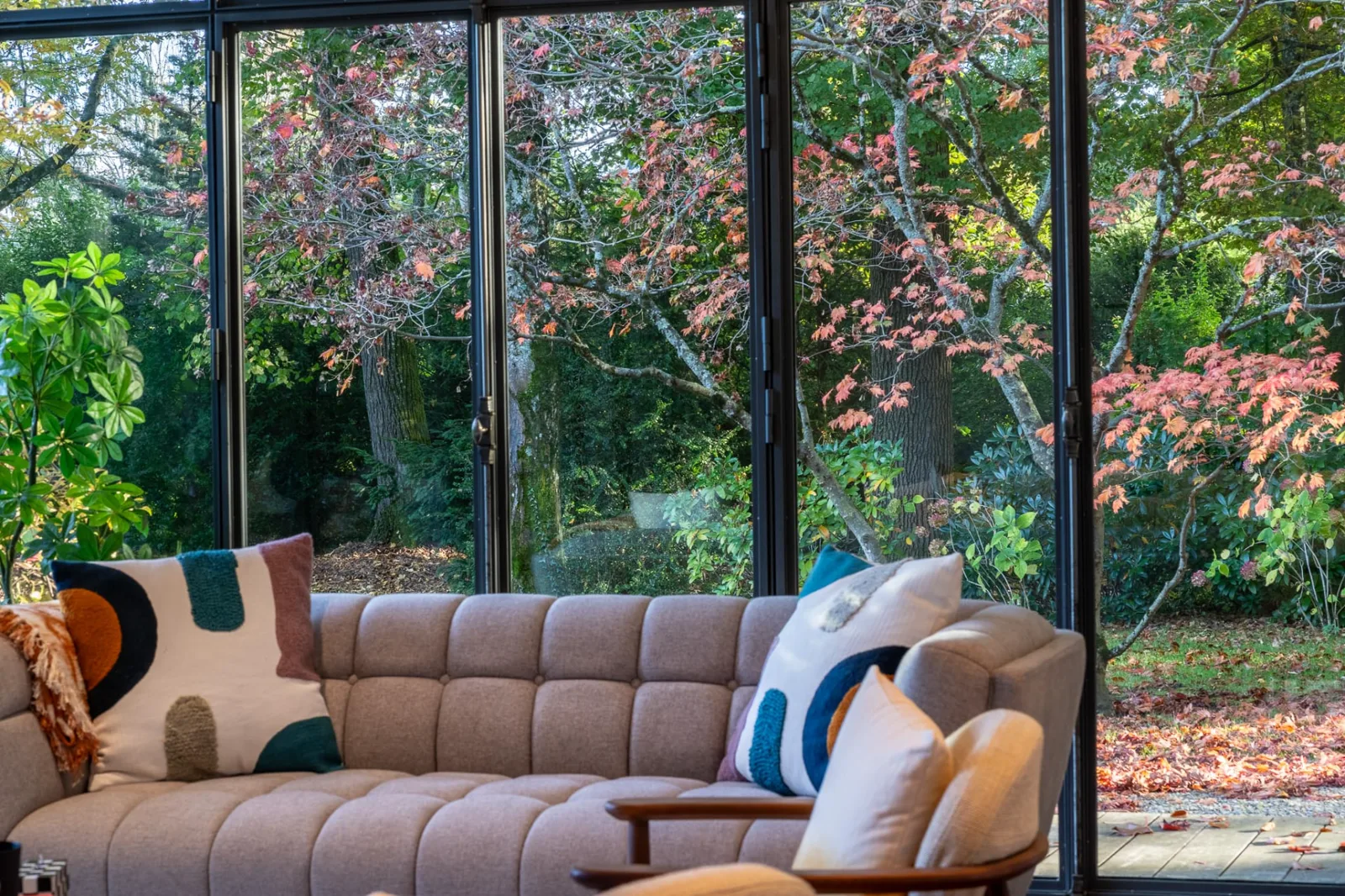 Salon ouvert sur un jardin arboré aux couleurs d'automne